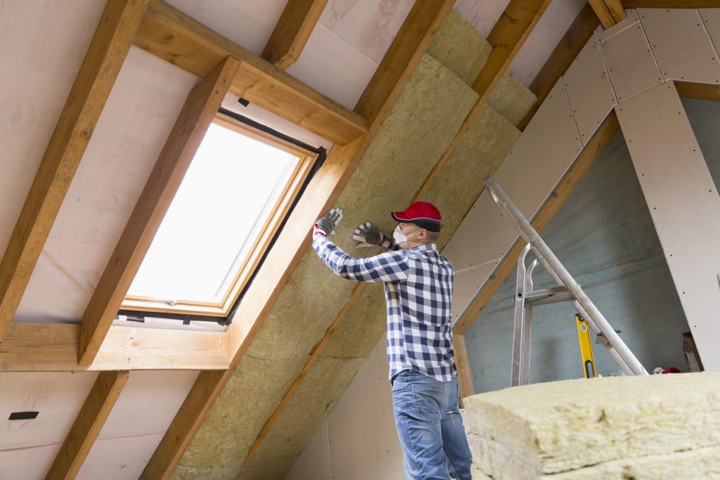 Man installing thermal roof insulation layer 